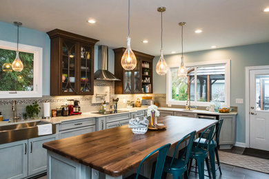 Expansive transitional l-shaped eat-in kitchen in Raleigh with a farmhouse sink, recessed-panel cabinets, white cabinets, wood benchtops, grey splashback, subway tile splashback, stainless steel appliances, ceramic floors, with island and grey floor.