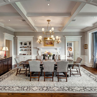 Cette image montre une salle à manger traditionnelle fermée avec un mur gris, une cheminée standard, un manteau de cheminée en bois et un sol en bois brun.
