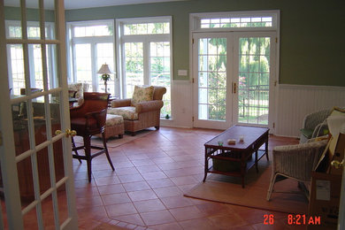 Imagen de sala de estar con barra de bar cerrada clásica de tamaño medio sin chimenea con paredes verdes y suelo de baldosas de porcelana