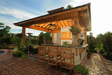 Inspiration for a mid-sized timeless backyard brick patio remodel in New Orleans with a roof extension