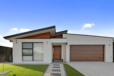 Photo of a large contemporary one-storey multi-coloured house exterior in Canberra - Queanbeyan with mixed siding, a shed roof and a black roof.