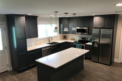Inspiration for a transitional l-shaped eat-in kitchen remodel in New Orleans with shaker cabinets, gray cabinets, quartz countertops, white backsplash, ceramic backsplash, stainless steel appliances and an island