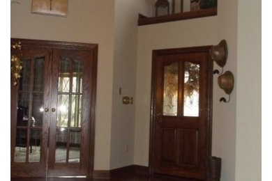 Large mountain style dark wood floor entryway photo in Other with beige walls and a dark wood front door