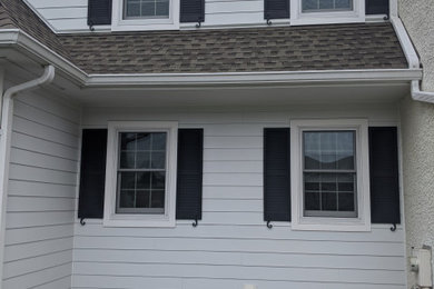 Mid-sized farmhouse white two-story concrete fiberboard and clapboard house exterior idea in Philadelphia with a shingle roof and a brown roof