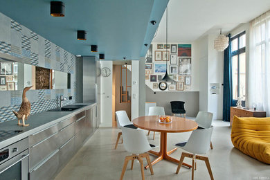 Photo of a large modern single-wall eat-in kitchen in Paris with a single-bowl sink, flat-panel cabinets, stainless steel cabinets, tile benchtops, blue splashback, cement tile splashback, stainless steel appliances, concrete floors and no island.