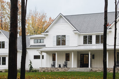 Imagen de fachada de casa blanca y gris campestre grande de dos plantas con revestimientos combinados, tejado a dos aguas, tejado de teja de madera y panel y listón