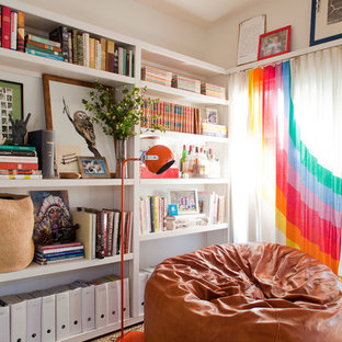 Ejemplo de biblioteca en casa bohemia con paredes blancas
