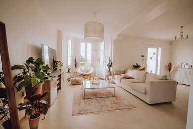 Living room with white walls, concrete floors and beige floor.