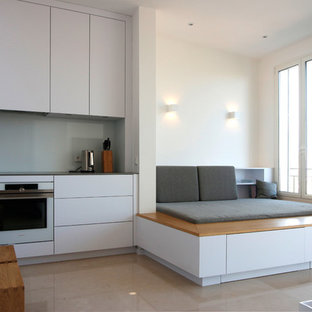 Foto di un piccolo soggiorno minimalista con pavimento in travertino e TV a parete