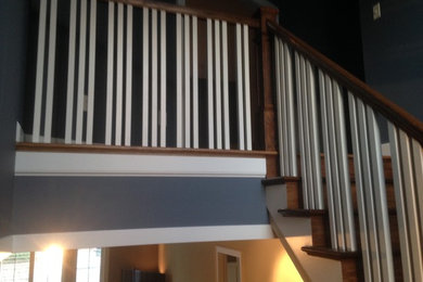 Ejemplo de escalera recta de estilo americano con escalones de madera y contrahuellas de madera