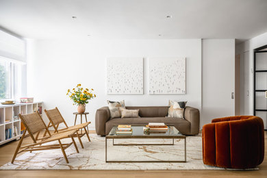 Großes, Offenes Modernes Wohnzimmer mit weißer Wandfarbe, braunem Holzboden und braunem Boden in New York