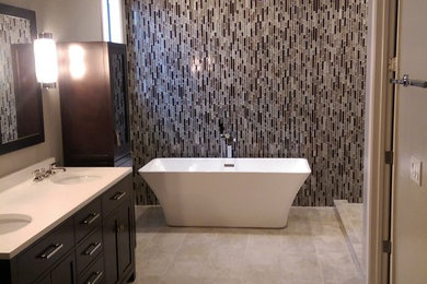 Freestanding bathtub - large contemporary master beige tile and porcelain tile travertine floor and beige floor freestanding bathtub idea in Phoenix with marble countertops, shaker cabinets, black cabinets and gray walls