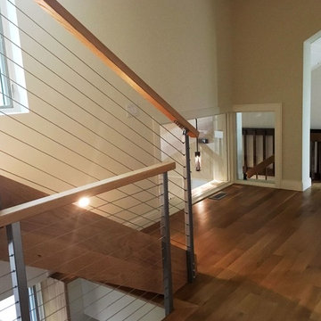 Open-riser stair and linkage of upper and lower level volumes of the home.