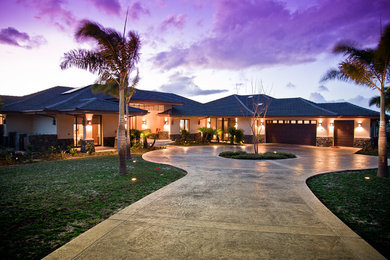 This is an example of a tropical one-storey stucco beige house exterior in Hawaii with a hip roof and a tile roof.