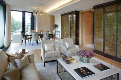 Mid-sized contemporary formal living room in London with beige walls, medium hardwood floors and a built-in media wall.