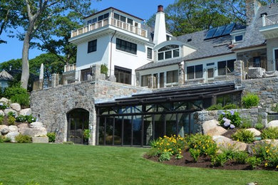 Photo of an expansive traditional three-storey grey exterior in Boston with stone veneer and a gable roof.