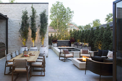 Example of a large trendy courtyard stone patio design in Denver with a fire pit and no cover