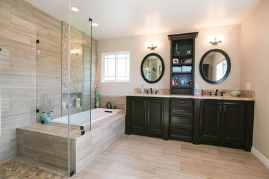 Large transitional master beige tile and porcelain tile porcelain tile and beige floor bathroom photo in Los Angeles with recessed-panel cabinets, black cabinets, beige walls, an undermount sink, marble countertops and a hinged shower door