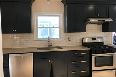 Open concept kitchen - mid-sized traditional beige floor open concept kitchen idea in Philadelphia with an undermount sink, shaker cabinets, black cabinets, granite countertops, white backsplash, subway tile backsplash and stainless steel appliances