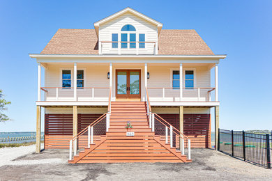 Trendy beige three-story concrete fiberboard and clapboard house exterior photo in Other with a shingle roof and a brown roof