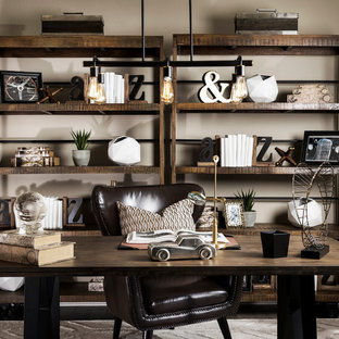 Foto på ett mellanstort industriellt hemmabibliotek, med beige väggar och ett fristående skrivbord