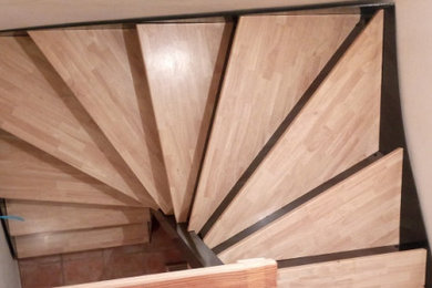Imagen de escalera de caracol actual pequeña con escalones de madera y contrahuellas de metal