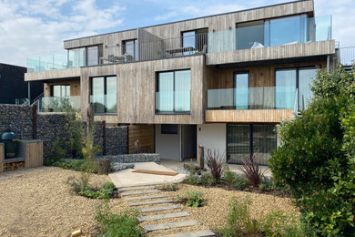 Ejemplo de fachada minimalista de tamaño medio de tres plantas con revestimiento de madera