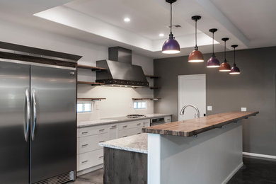 Inspiration for a mid-sized contemporary galley eat-in kitchen in Other with a drop-in sink, flat-panel cabinets, white cabinets, white splashback, stainless steel appliances, concrete floors, with island and grey floor.