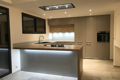 This is an example of a mid-sized contemporary u-shaped eat-in kitchen in Marseille with a single-bowl sink, flat-panel cabinets, brown cabinets, laminate benchtops, grey splashback, glass sheet splashback, stainless steel appliances, limestone floors, a peninsula and beige floor.