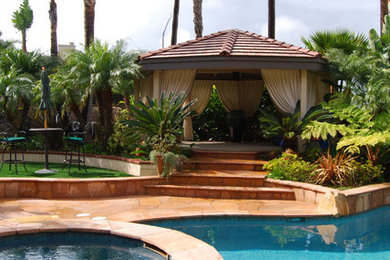 Inspiration for a large mediterranean backyard stone and custom-shaped natural pool house remodel in Orange County