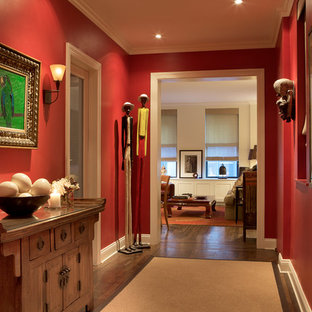 Idéer för en eklektisk entré, med röda väggar och mörkt trägolv