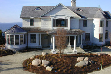 Inspiration for a large timeless gray three-story wood exterior home remodel in Other with a hip roof