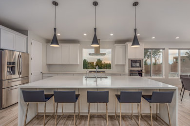 Eat-in kitchen - large contemporary l-shaped porcelain tile and multicolored floor eat-in kitchen idea in Albuquerque with an undermount sink, recessed-panel cabinets, white cabinets, quartzite countertops, white backsplash, porcelain backsplash, stainless steel appliances, an island and white countertops