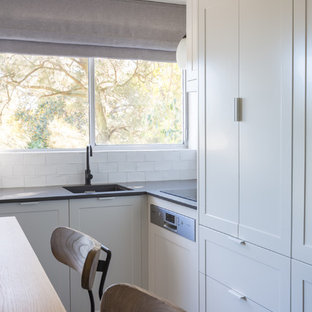 Создайте стильный интерьер: маленькая угловая кухня-гостиная в стиле модернизм с врезной раковиной, фасадами с утопленной филенкой, белыми фасадами, столешницей из кварцевого композита, белым фартуком, фартуком из керамической плитки, техникой из нержавеющей стали, полом из линолеума и зеленым полом без острова - последний тренд