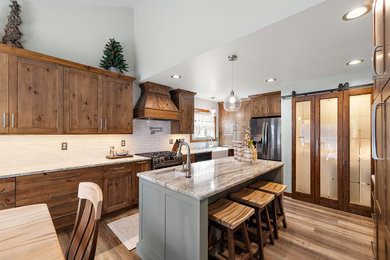 Eat-in kitchen - mid-sized cottage l-shaped vinyl floor, brown floor and vaulted ceiling eat-in kitchen idea in Detroit with a farmhouse sink, shaker cabinets, medium tone wood cabinets, granite countertops, white backsplash, ceramic backsplash, stainless steel appliances, an island and beige countertops