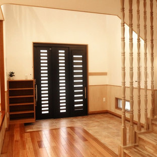 他の地域の引き戸アジアンスタイルのおしゃれな玄関ホール (セラミックタイルの床、黒いドア、ターコイズの床) の写真