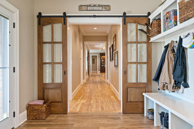 他の地域にある高級な広いトラディショナルスタイルのおしゃれなマッドルーム (グレーの壁、セラミックタイルの床、木目調のドア、ベージュの床) の写真