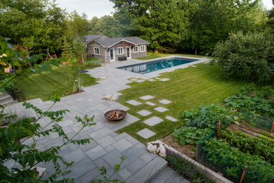 Inspiration for a large transitional backyard concrete paver landscaping in Toronto.