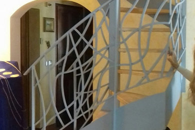 Diseño de escalera en U contemporánea pequeña con escalones de pizarra y barandilla de metal