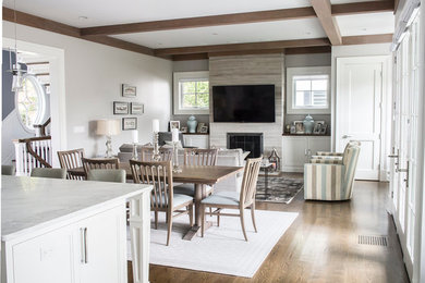 Large transitional open concept medium tone wood floor family room photo in New York with gray walls, a standard fireplace, a stone fireplace and a wall-mounted tv