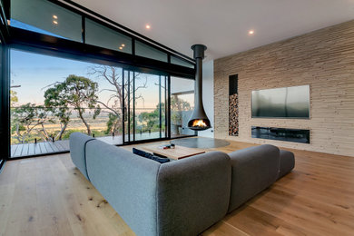 Photo of a contemporary living room in Melbourne with a hanging fireplace.