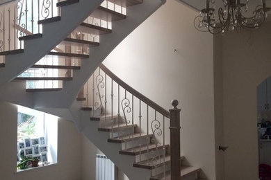 Пример оригинального дизайна: большая п-образная лестница в викторианском стиле с деревянными ступенями и металлическими перилами