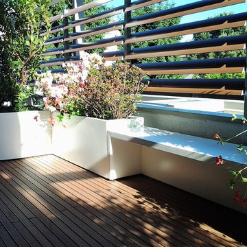 Terrazzo con fioriere bianche, panca e mascheramento