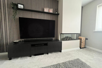 Design ideas for a medium sized contemporary enclosed living room in Other with beige walls, carpet and a wall mounted tv.