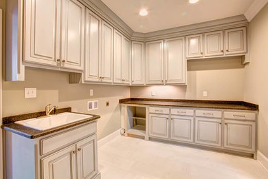 Design ideas for a large traditional l-shaped dedicated laundry room in Other with an undermount sink, white cabinets, white walls, ceramic floors and a side-by-side washer and dryer.