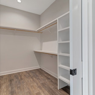 Example of a mid-sized cottage gender-neutral vinyl floor and brown floor walk-in closet design in Jacksonville