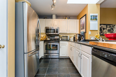 Kitchen - mid-sized modern u-shaped kitchen idea in Vancouver with white cabinets and stainless steel appliances