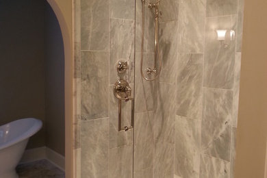 シャーロットにある広いおしゃれなマスターバスルーム (シェーカースタイル扉のキャビネット、白いキャビネット、置き型浴槽、分離型トイレ、白いタイル、石タイル、グレーの壁、大理石の床) の写真