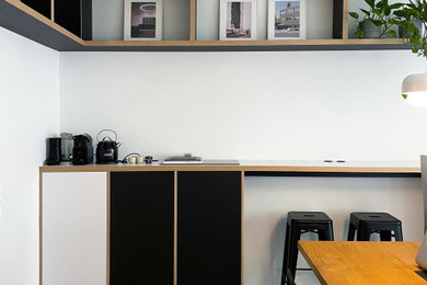 Ejemplo de despacho moderno de tamaño medio con paredes blancas, escritorio empotrado y madera