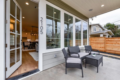 Inspiration for a large transitional concrete front porch remodel in Austin with a roof extension